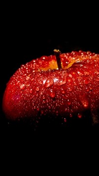 Czerwone jabłko w kroplach wody
