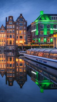 Domy i kanał w Amsterdamie nocą