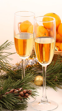 Dwa kieliszki szampana z mandarynkami w tle