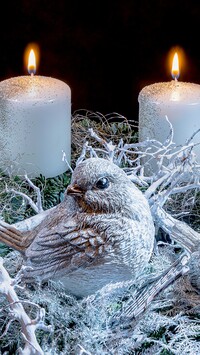 Figurka ptaszka przy zapalonych świecach