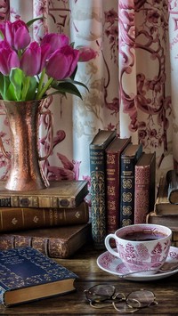 Filiżanka kawy obok książek