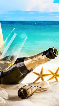 Kieliszek i butelka szampana na plaży