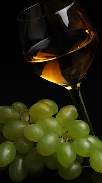 Kieliszek wina obok winogron