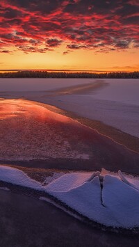 Kolorowy zachód słońca nad zamarzniętym jeziorem