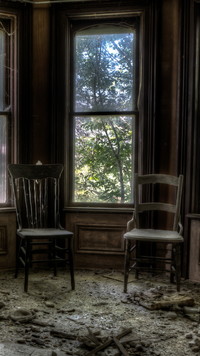 Krzesła pod oknem w zaniedbanym pomieszczeniu