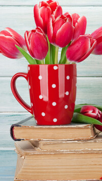 Kubek z tulipanami na książkach