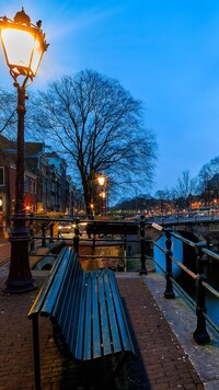 Latarnia i ławka nad kanałem w Amsterdamie
