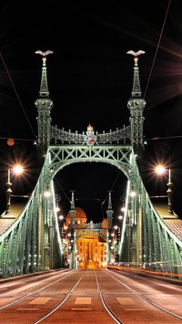 Oświetlony żelazny most zaprasza do miasta