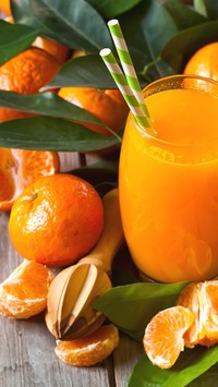 Szklanka soku pomarańczowego ze słomkami
