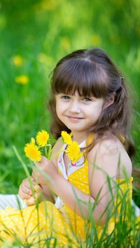 Uśmiechnięta dziewczynka z żółtymi kwiatkami na letniej łące