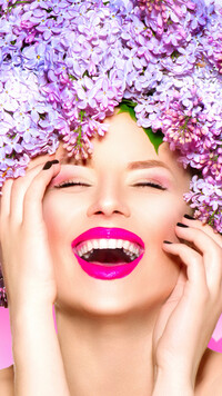 Uśmiechnięta kobieta z kwiatami bzu