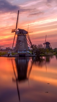 Wiatraki nad rzeką w Holandii o zachodzie słońca