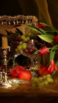 Winogrona koło świecy i tulipanów