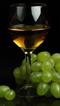 Winogrona obok kieliszka z winem