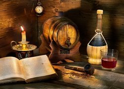 Antałek i butelka wina obok książki i świecy
