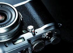 Aparat fotograficzny marki Fujifilm X 100s na czarnym tle