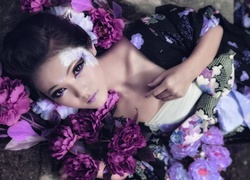 Azjatka w ciekawym makijażu pośród fioletowych kwiatów