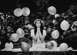 Balony fruwające wokół kobiety w modlitewnej pozie