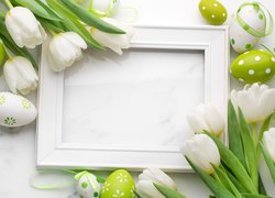 Biała ramka pośród tulipanów i pisanek