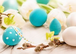 Biało-niebieskie jajka przy gałązkach leszczyny