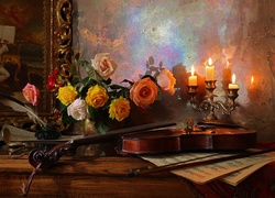 Bukiet róż obok skrzypiec w blasku świec