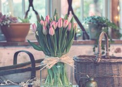 Bukiet różowych tulipanów w wazonie obok koszyków