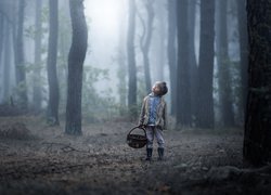 Chłopiec z koszykiem w lesie