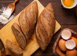 Ciemny chleb na desce obok jajek i mąki