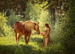 Ciężarna kobieta obok konia
