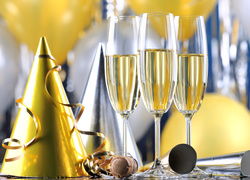 Czapeczka, serpentyny i szampan w kieliszkach na powitanie Nowego Roku