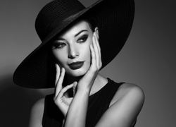 Czarno-białe zdjęcie eleganckiej kobiety w kapeluszu