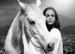 Czarno-białe zdjęcie kobiety przytulającej konia