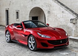 Czerwone Ferrari Portofino przed budynkiem