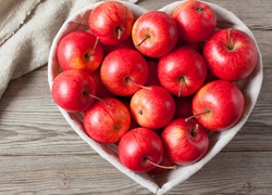 Czerwone jabłka w koszyku w kształcie serca