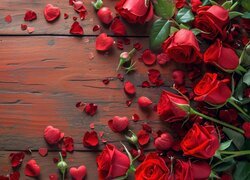 Czerwone róże i płatki róż na deskach