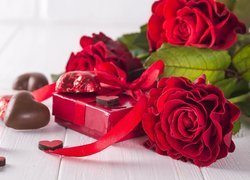Czerwone róże obok czekoladek