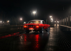 Czerwony Ford Mustang w deszczową noc