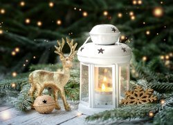 Dekoracja świąteczna z lampionem i jelonkiem obok gałązki świerku