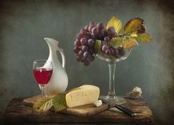 Deska z serem i lampką wina obok winogron