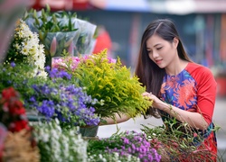 Długowłosa Azjatka przy stoisku z kwiatami