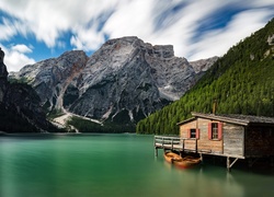 Domek i łódki na jeziorze Pragser Wildsee we włoskich Dolomitach