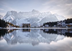 Domy i Grand Hotel Misurina nad jeziorem na tle ośnieżonych Dolomitów