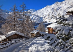 Domy przy drodze w szwajcarskiej miejscowości Saas-Fee zimą