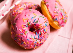 Donuty - pączki z dziurką w różowym lukrze ozdobione posypką