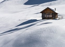 Drewniany domek na zaśnieżonym wzgórzu