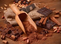 Drewniany nabierak z kakao obok czekolady