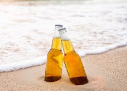 Dwie butelki piwa w piasku