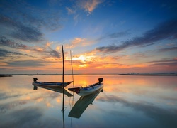 Dwie łodzie na jeziorze w blasku zachodzącego słońca