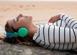 Dziewczyna ze słuchawkami na plaży