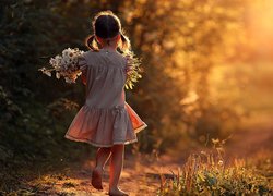 Dziewczynka w sukience z bukietem kwiatów